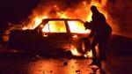 Manifestanti bruciano un'auto a Tripoli